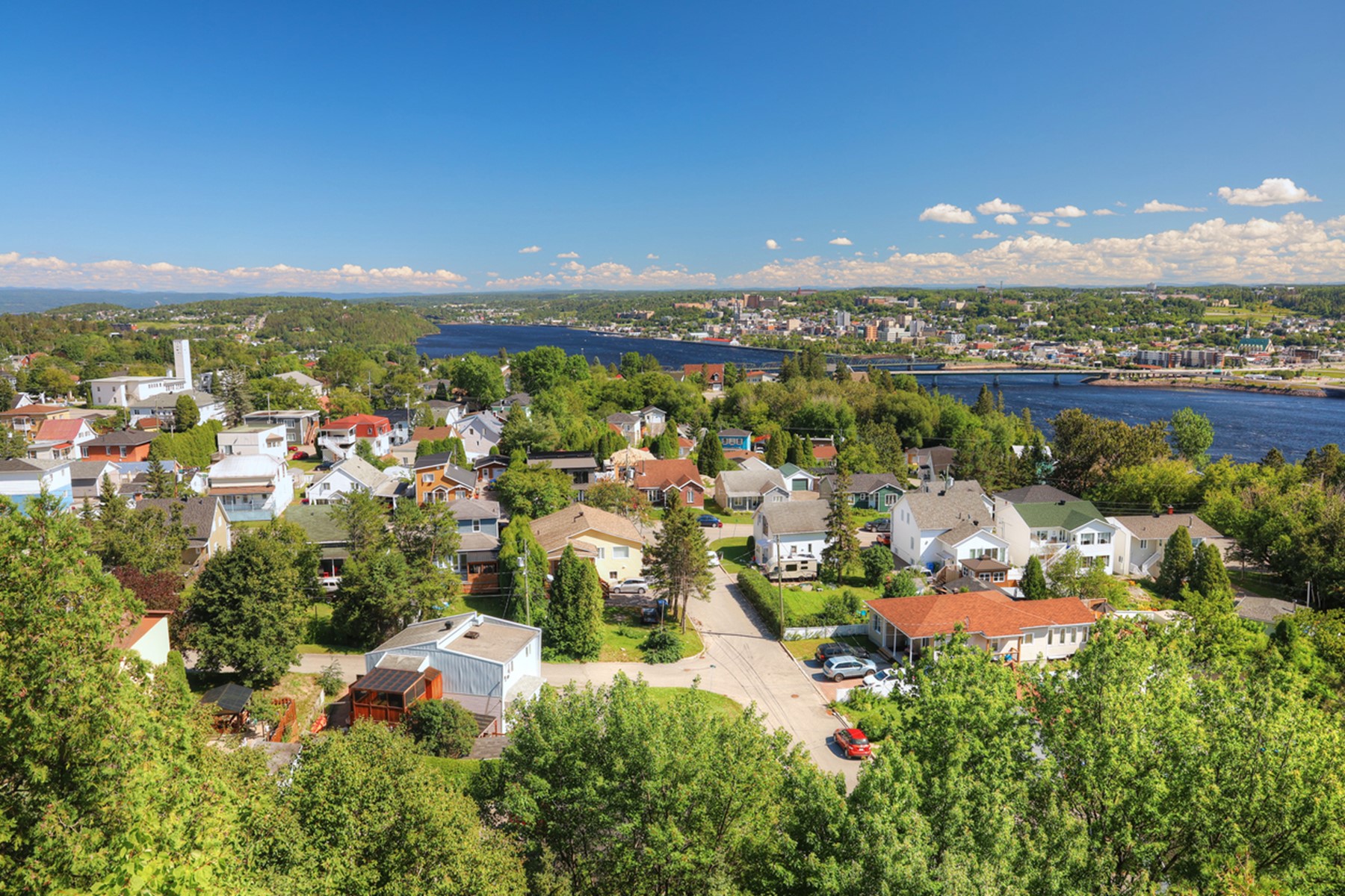 Vue aérienne et estivale d’un quartier résidentiel de la ville de Saguenay près de la rivière du même nom. 