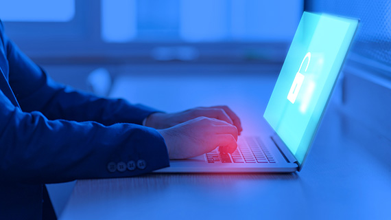 Une personne se connecte à son ordinateur où apparaît une icône de verrouillage sur l'écran.