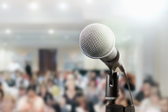 Gros plan d'un microphone sur une scène devant une grande conférence de presse.